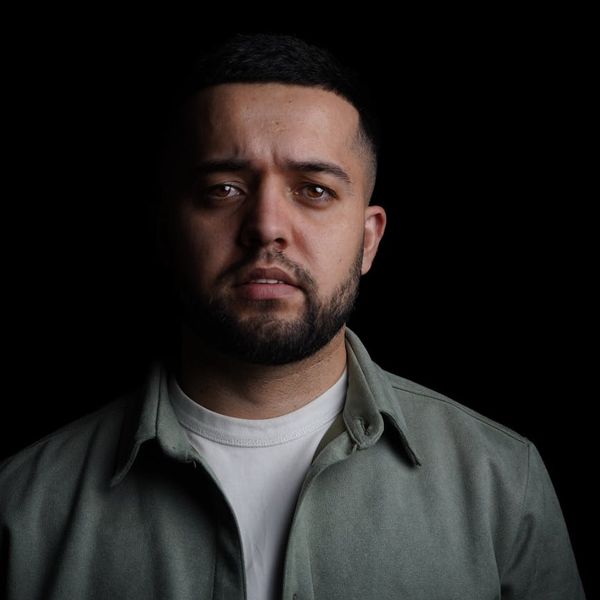 Silhouette of a man in a meditative pose against a dark, textured background.